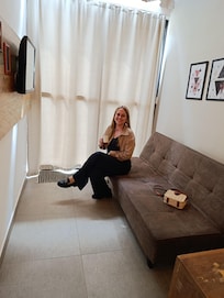 Sala com tv e sofá que vira uma ótima cama tb. Bom pra maratonar as séries.