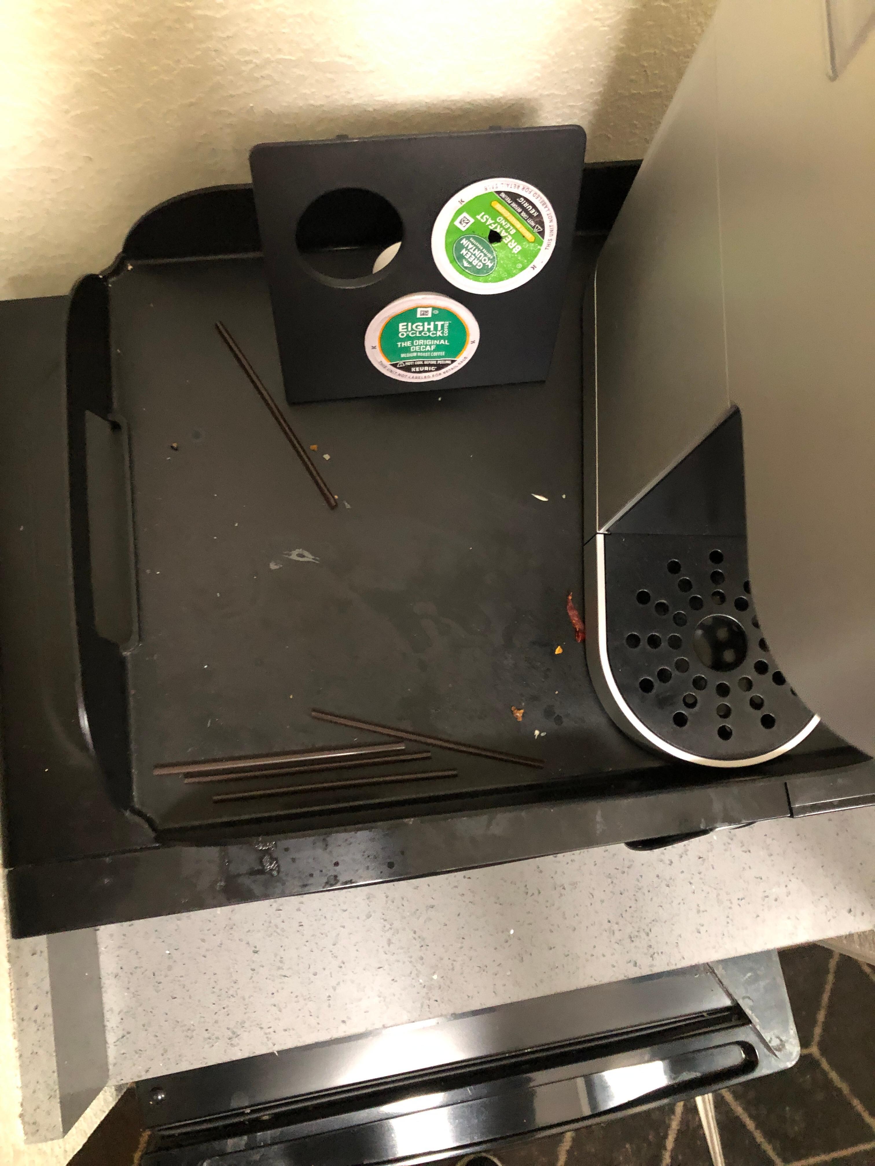 Coffee area. No cups, straws everywhere and coffee pod punctured. 