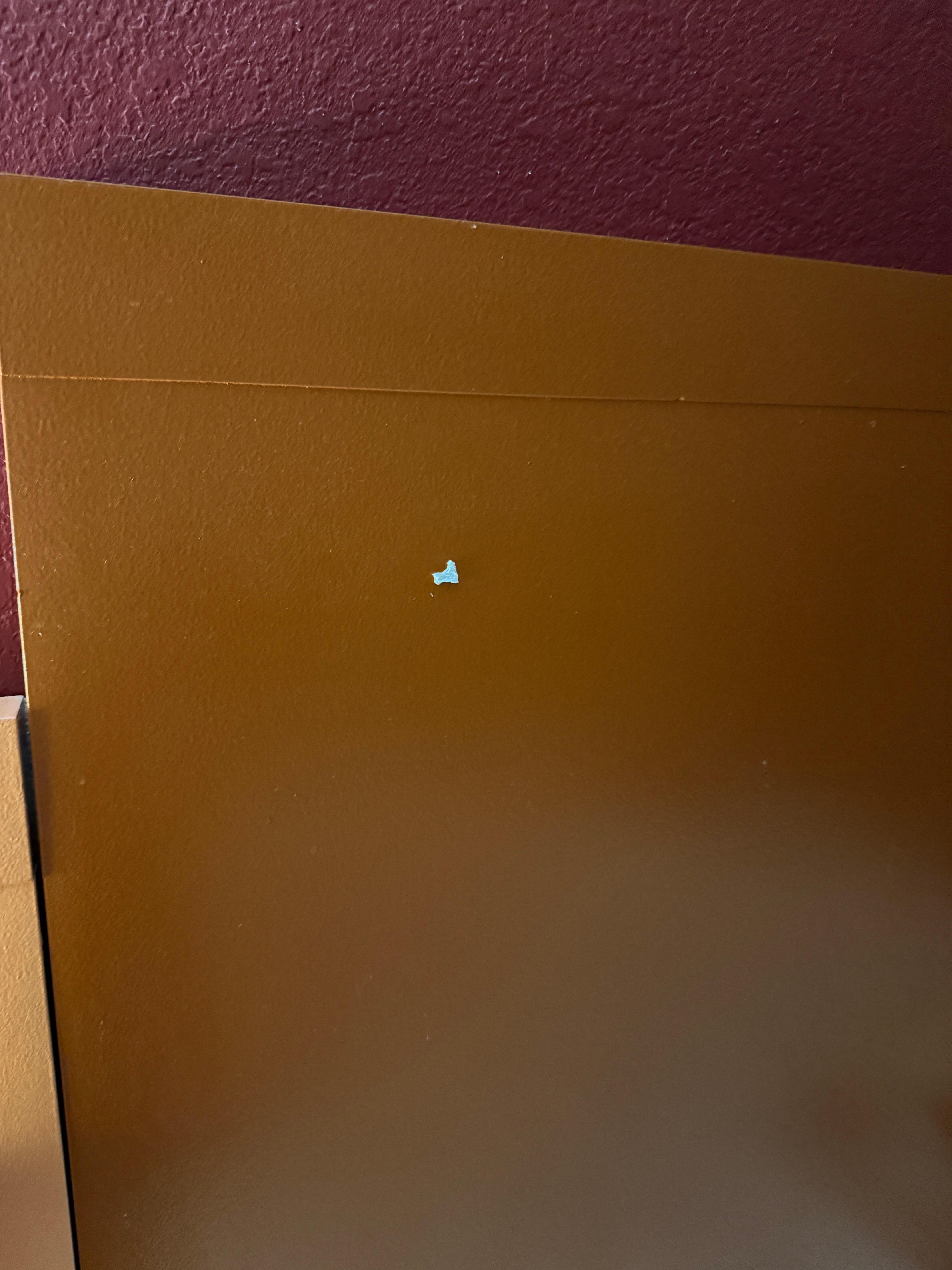 The headboard with two-sided tape stuck to it 