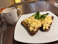 Scrambled egg on toast with avocado and coffee on the side!