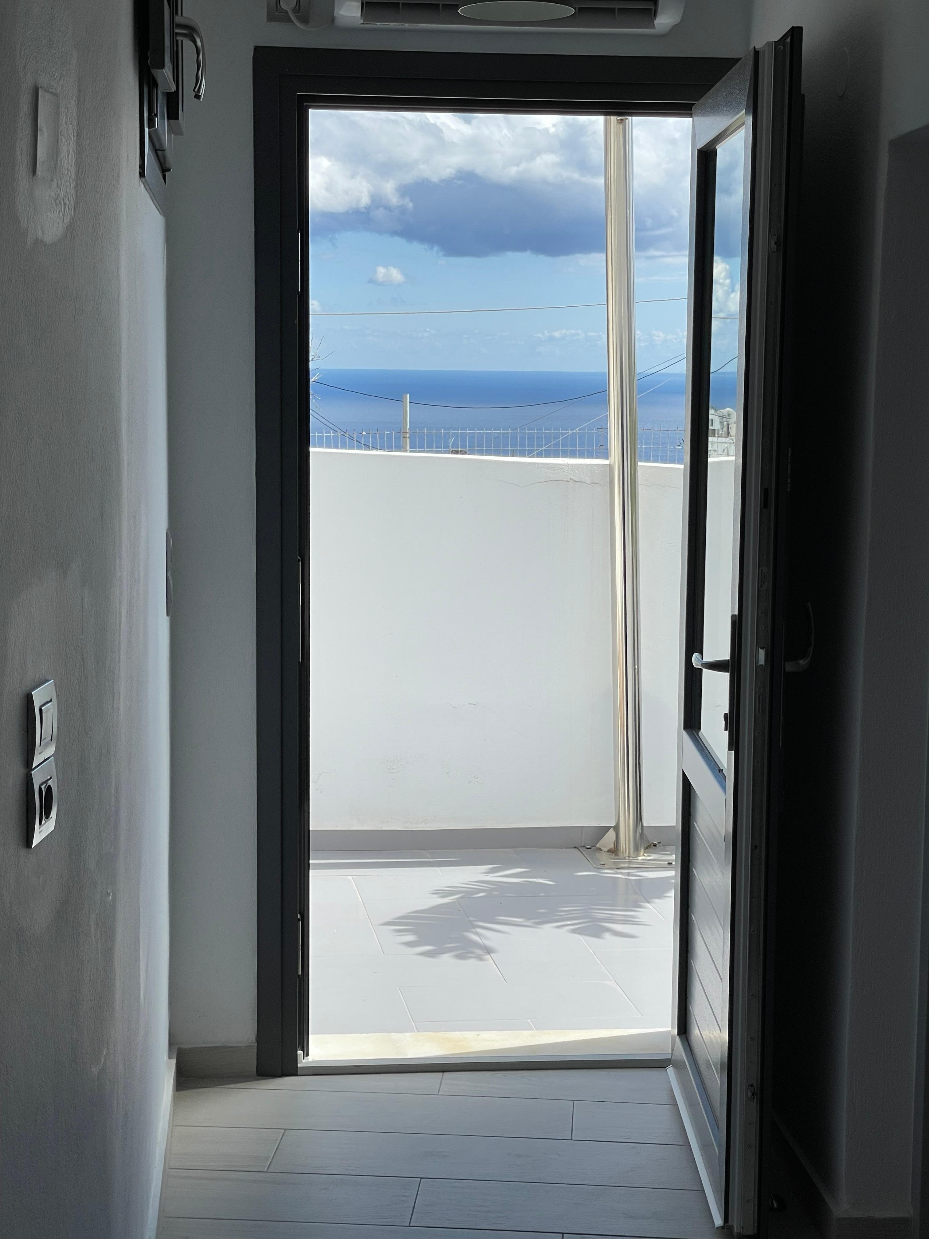 View from inside out onto the patio, where you can see the sea 