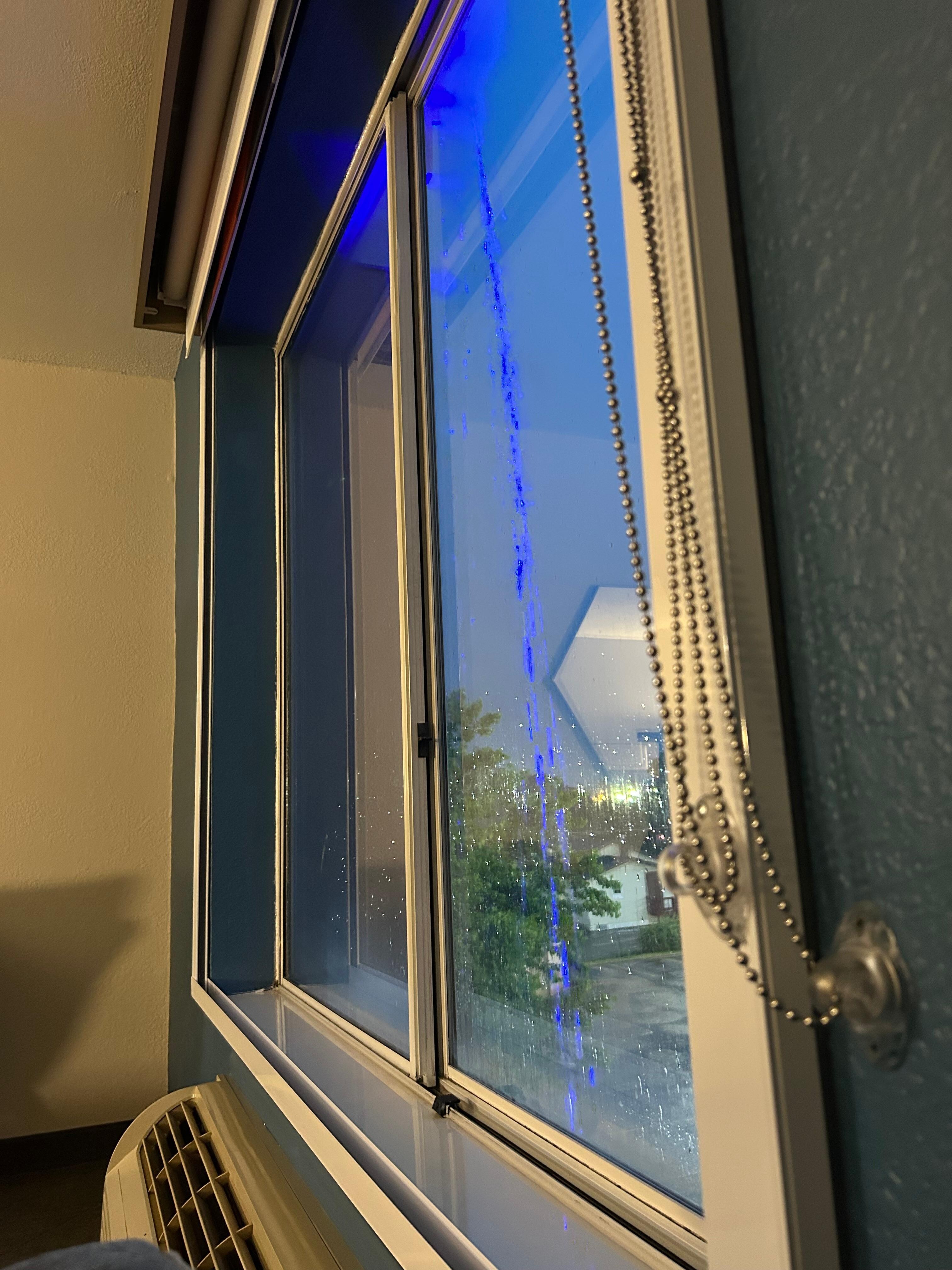 Rain dripping off the roof with the blue lights 