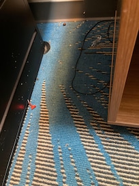 Trash on the floor under the side of the bed
