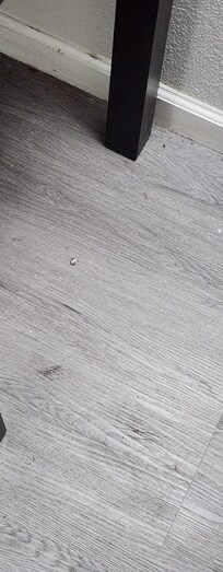 Trash and dirt on the floor by the table