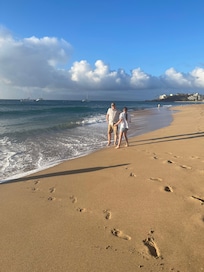 Beautiful sand beach next to pool with walkway going along hotel zone