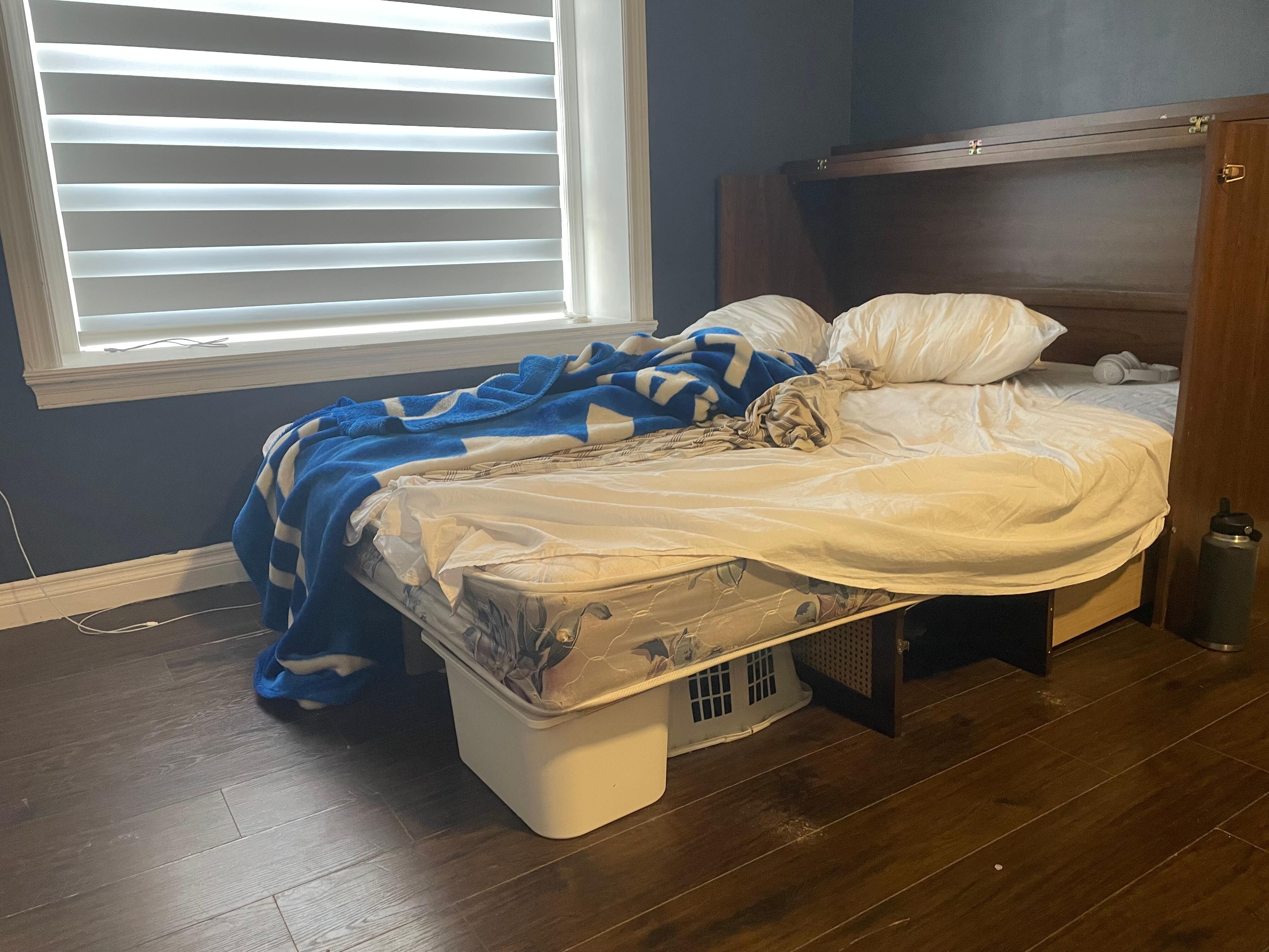 Broken, slanted queen fold out bed against the wall so only one person could get in and out easily.