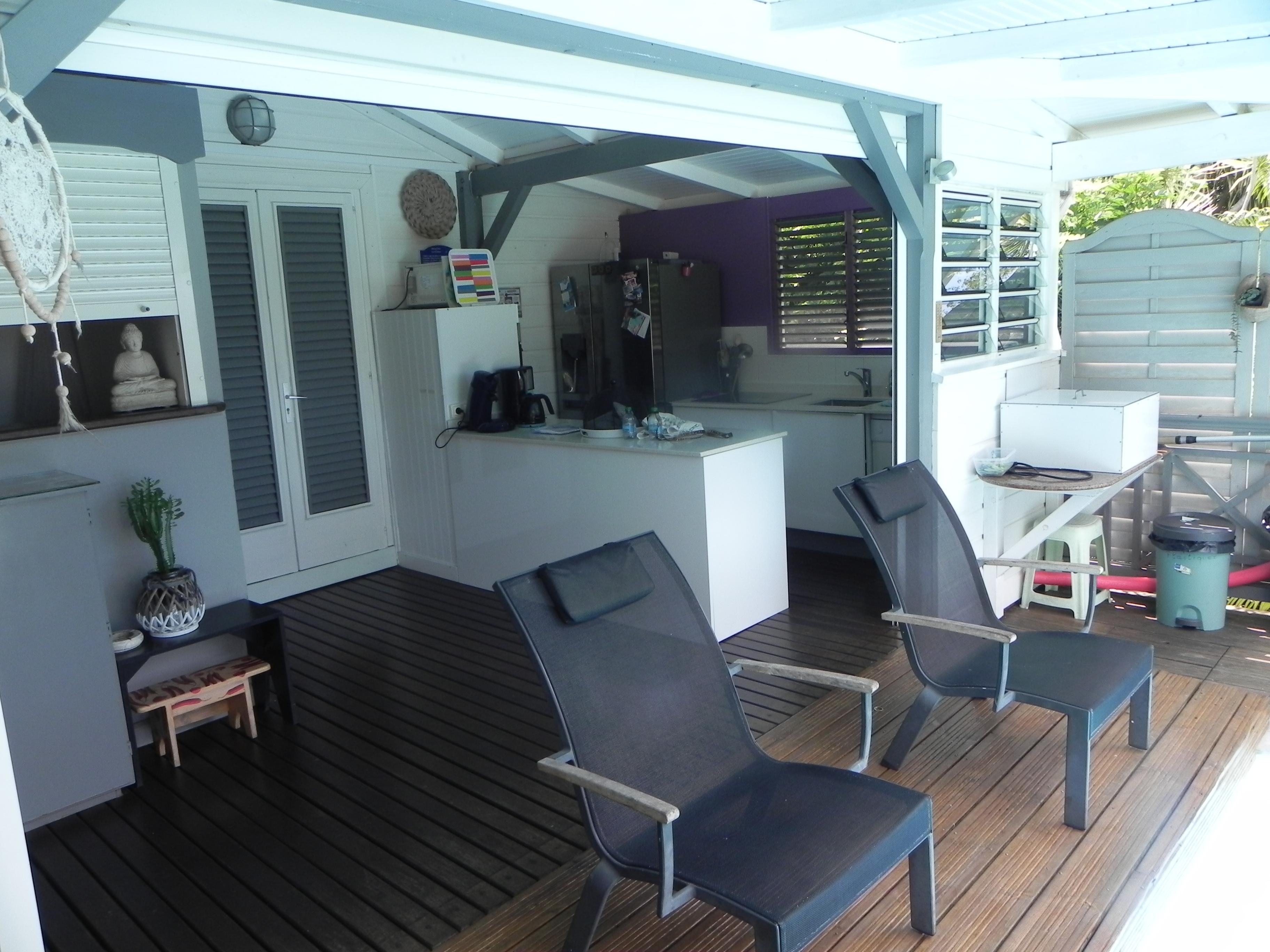 Pool deck with kitchen behind and separating garage like doors seen above.