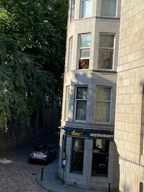 Sitting in the window seat overlooking the street.