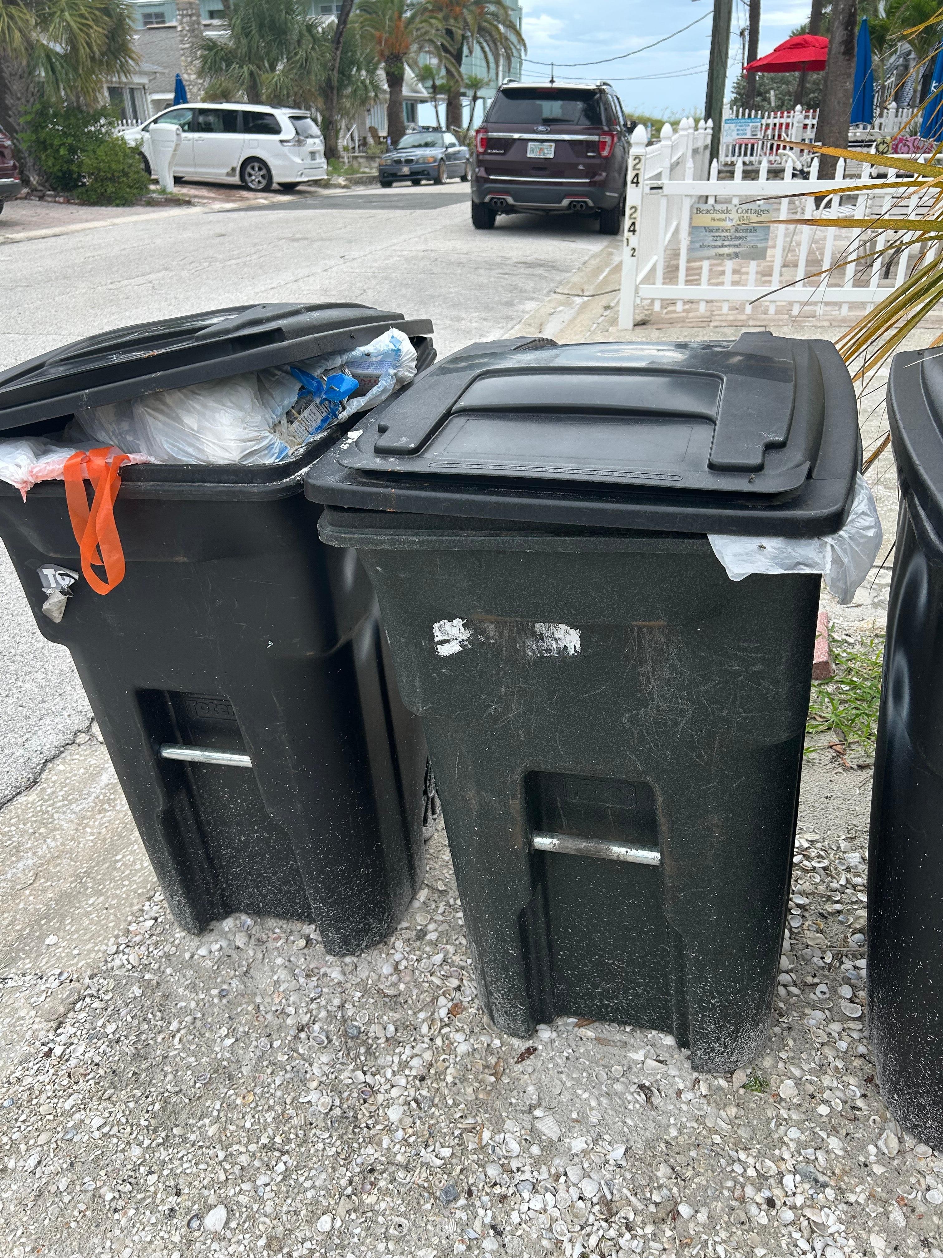 3 garbage cans filled to rim upon arriving.