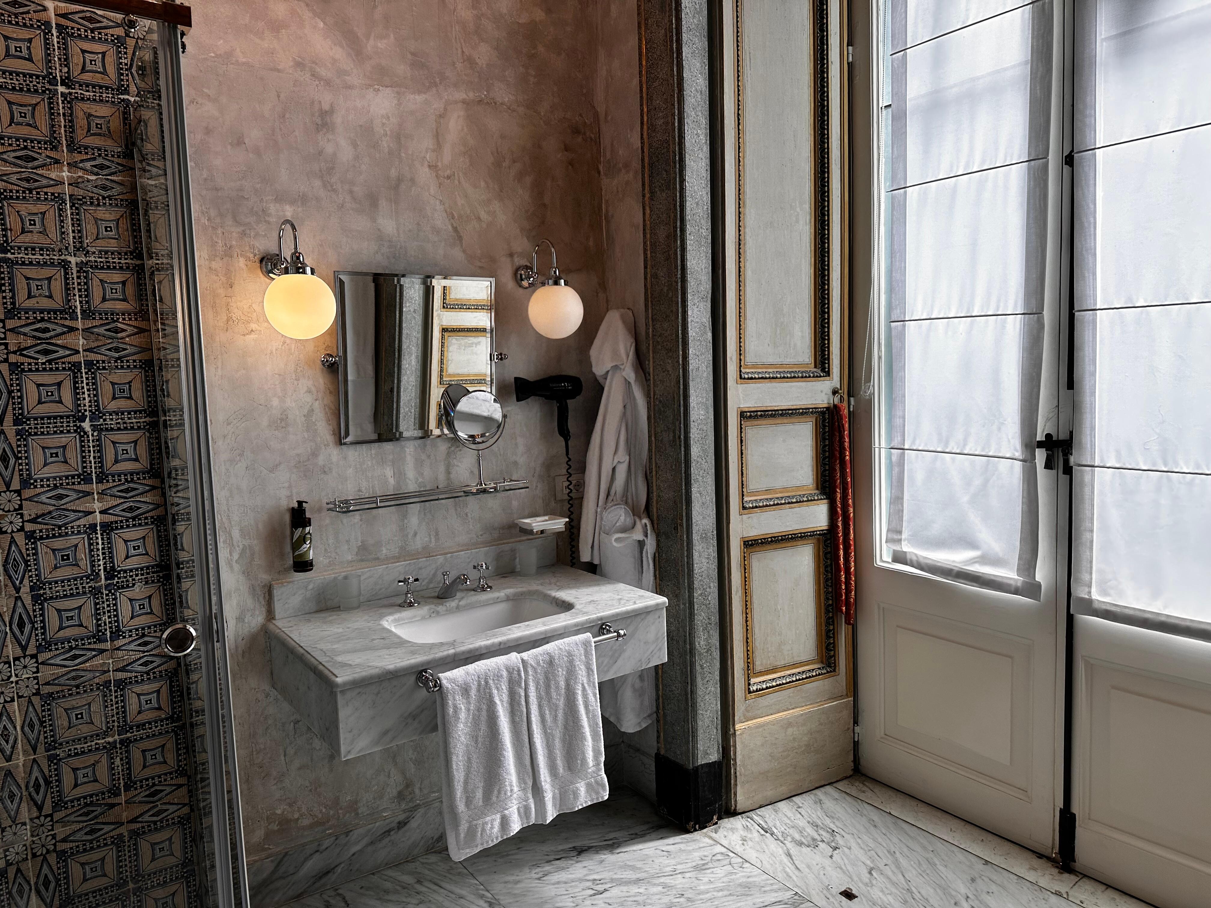 Deluxe room bathroom vanity.  The doors overlook the alleyway.