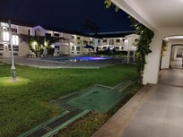 Área común y alberca durante la noche.