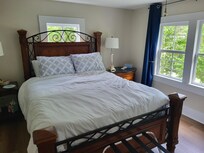 Upstairs bedroom with no curtain on window over headboard.