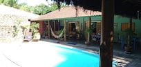 Piscina com área do cafe da manhã ao fundo.
