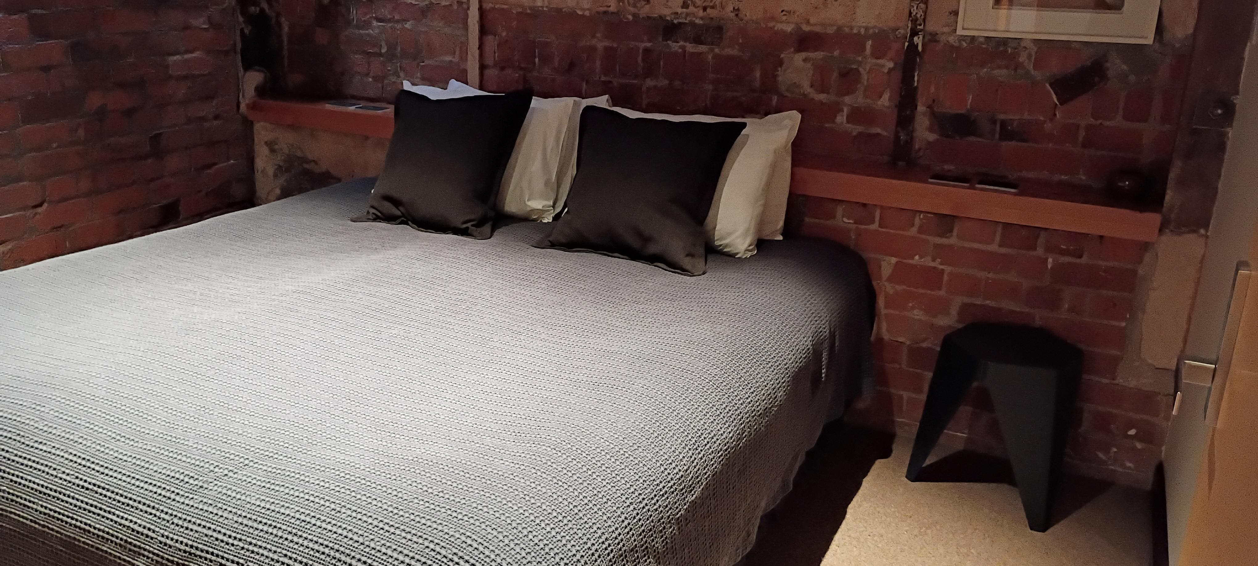 Bedroom on the first floor.  Interesting architectural add was the clear glass in the left corner that allowed natural sunlight in from the living room window