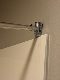 Shower rod is not hanging correctly, so curtain falls to the middle.