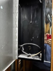 empty cabinet in the lift where the emergency phone should be