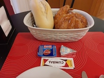 Frokosten. Lyst brød, syltetøy, ost, smør, kaffe