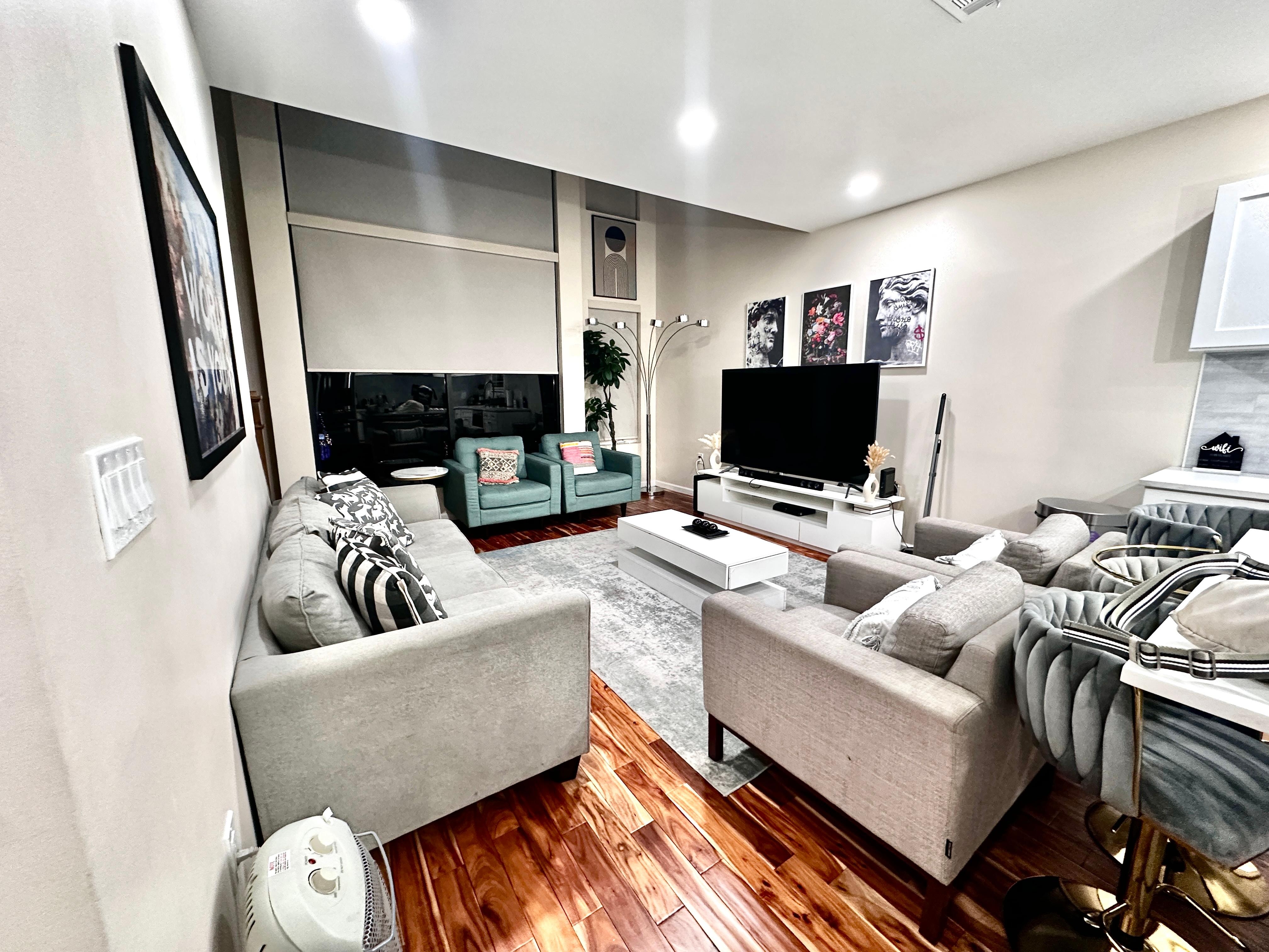 Main living space — fairly cozy but amazing tall ceilings & huge tv. 