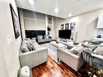 Main living space — fairly cozy but amazing tall ceilings & huge tv.