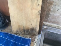 The cutting board covered in mould.