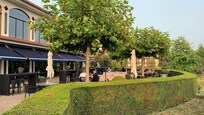 Outdoor terrace with a view of fields. Playground next to it.