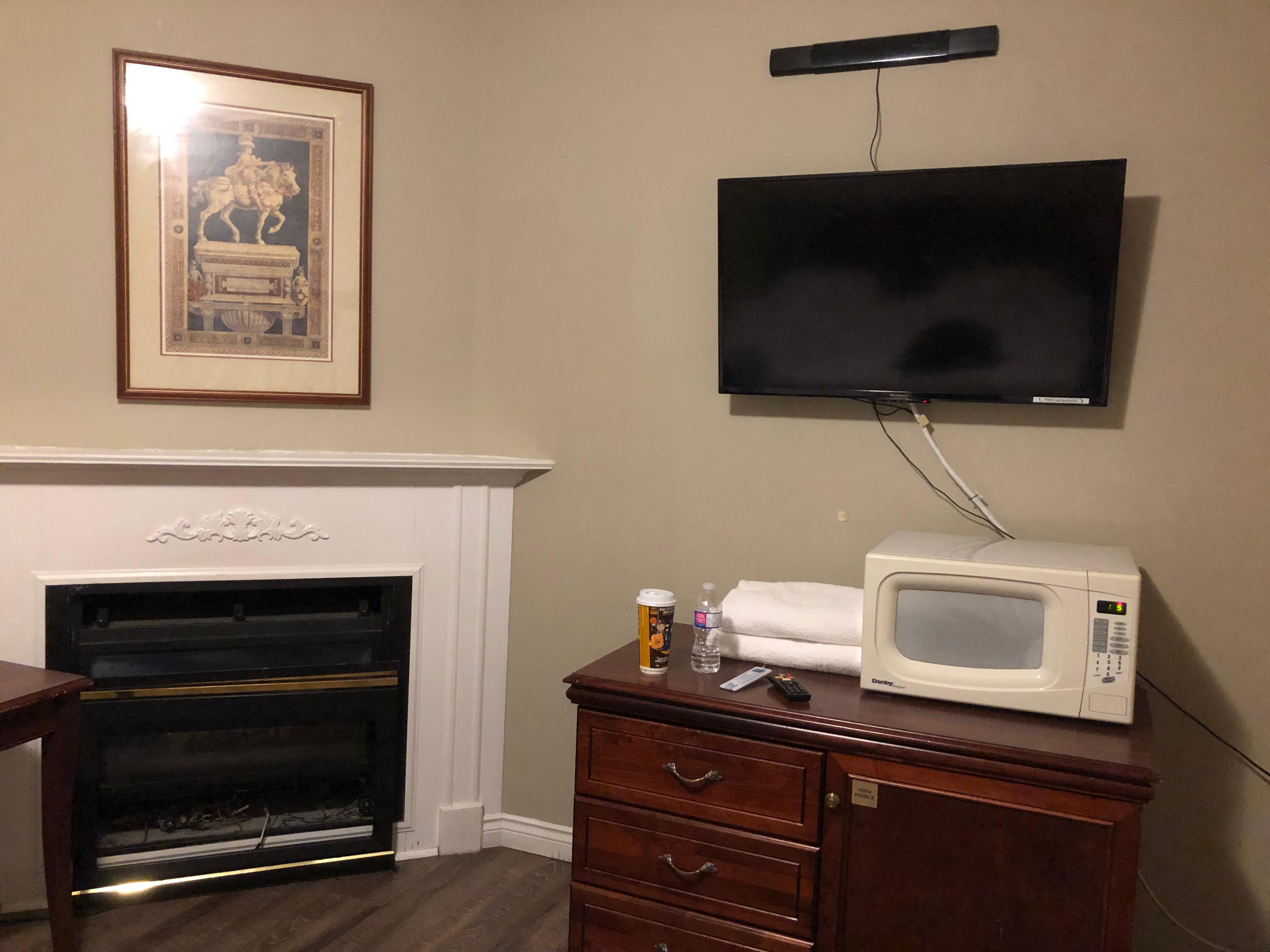 There was a fireplace in the room with microwave and fridge