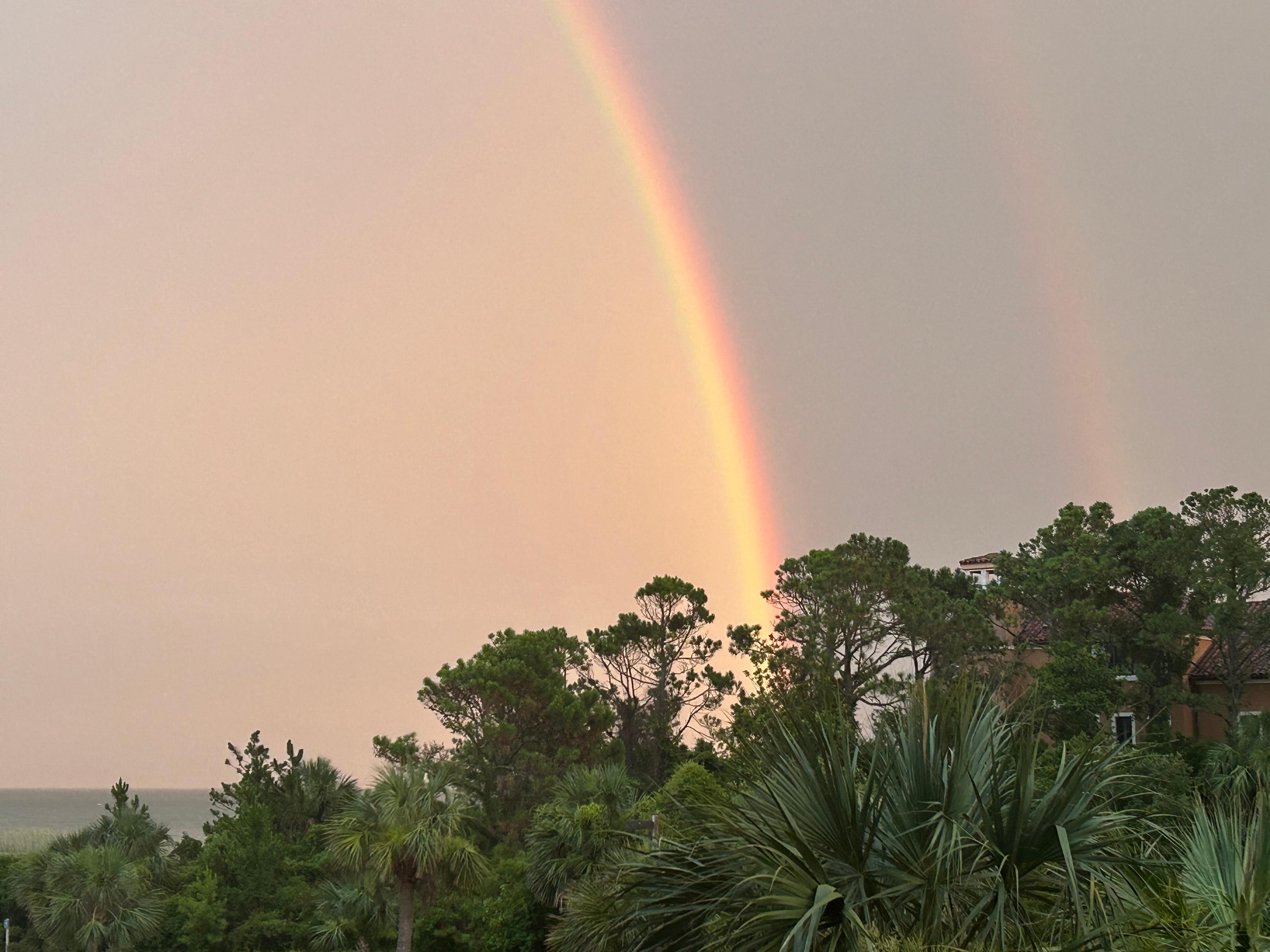 View from balcony of double rainbow over the ocean 