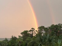 View from balcony of double rainbow over the ocean