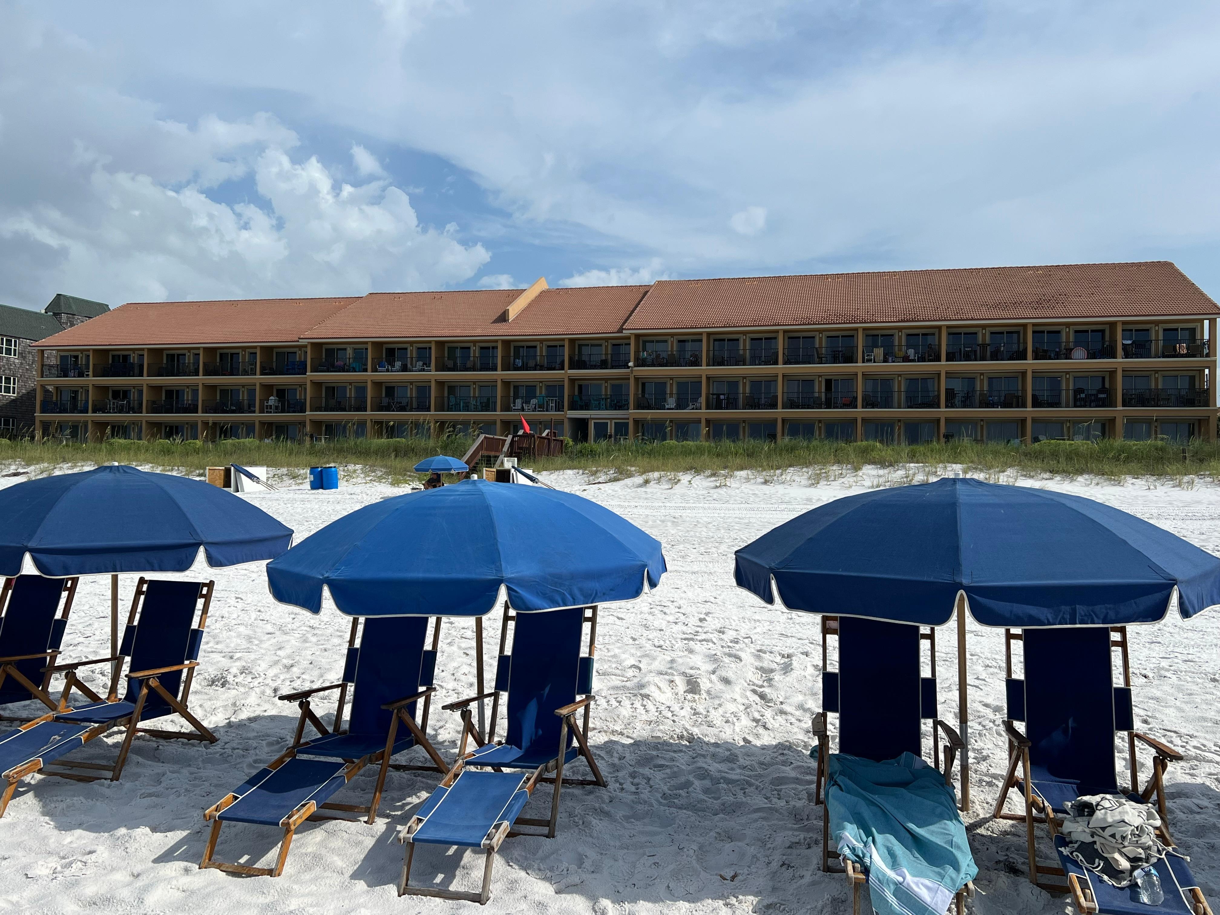 Beach chairs and umbrella with Coral Reef Club in the background. 