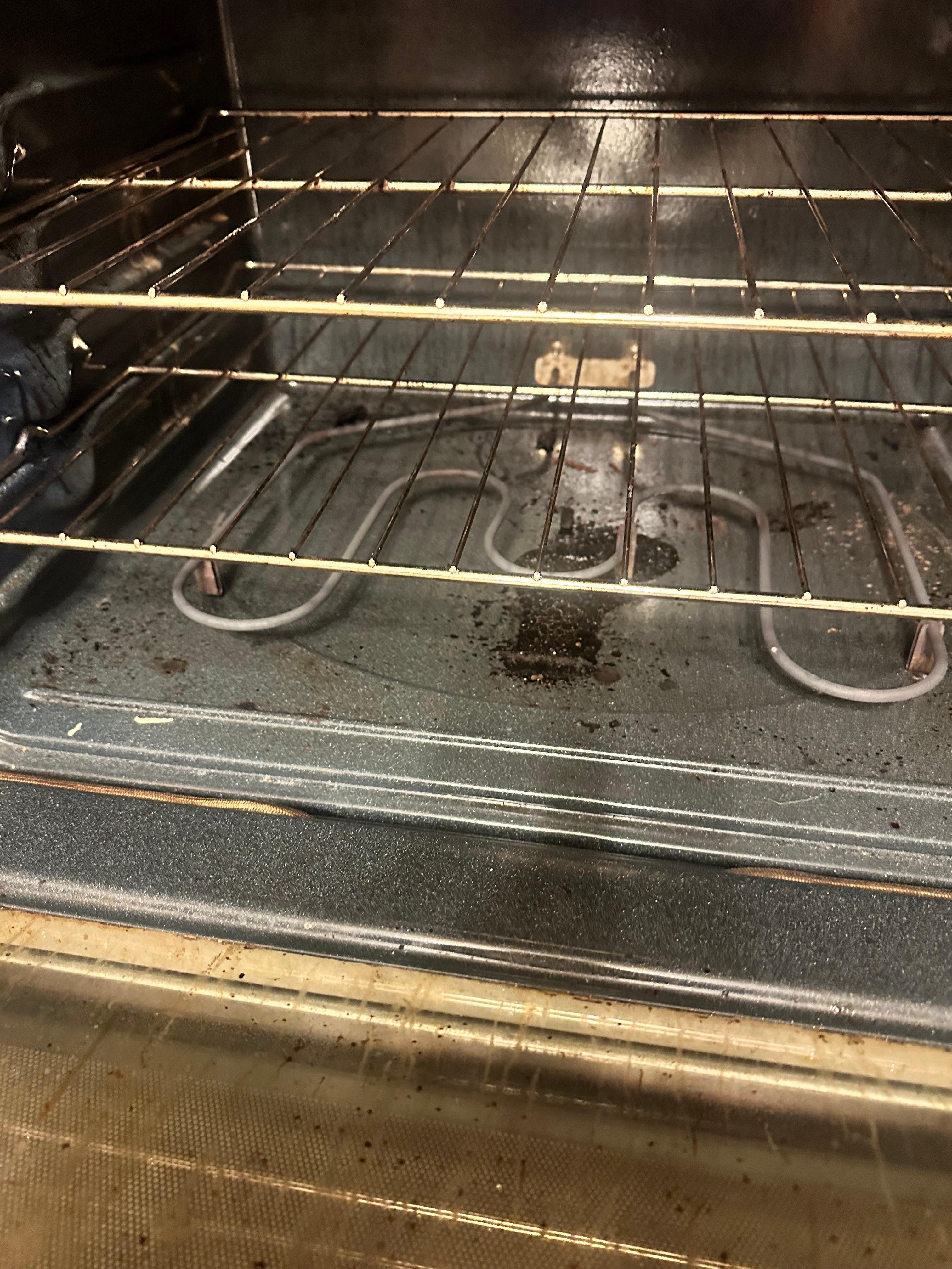 Dirty oven with burnt food on the bottom