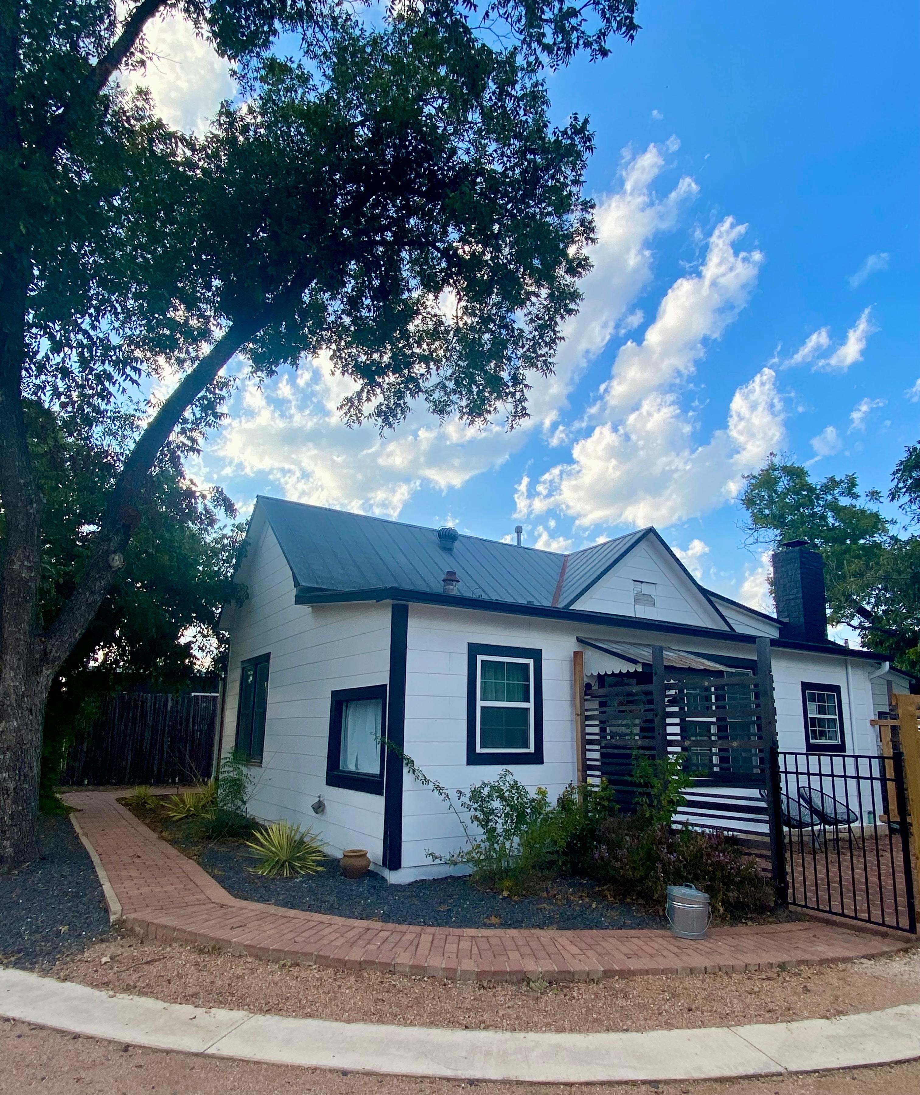 Corner view of the Main House with back gated hot tub area and kitchen door entrance. All right next to the reserved parking spaces.