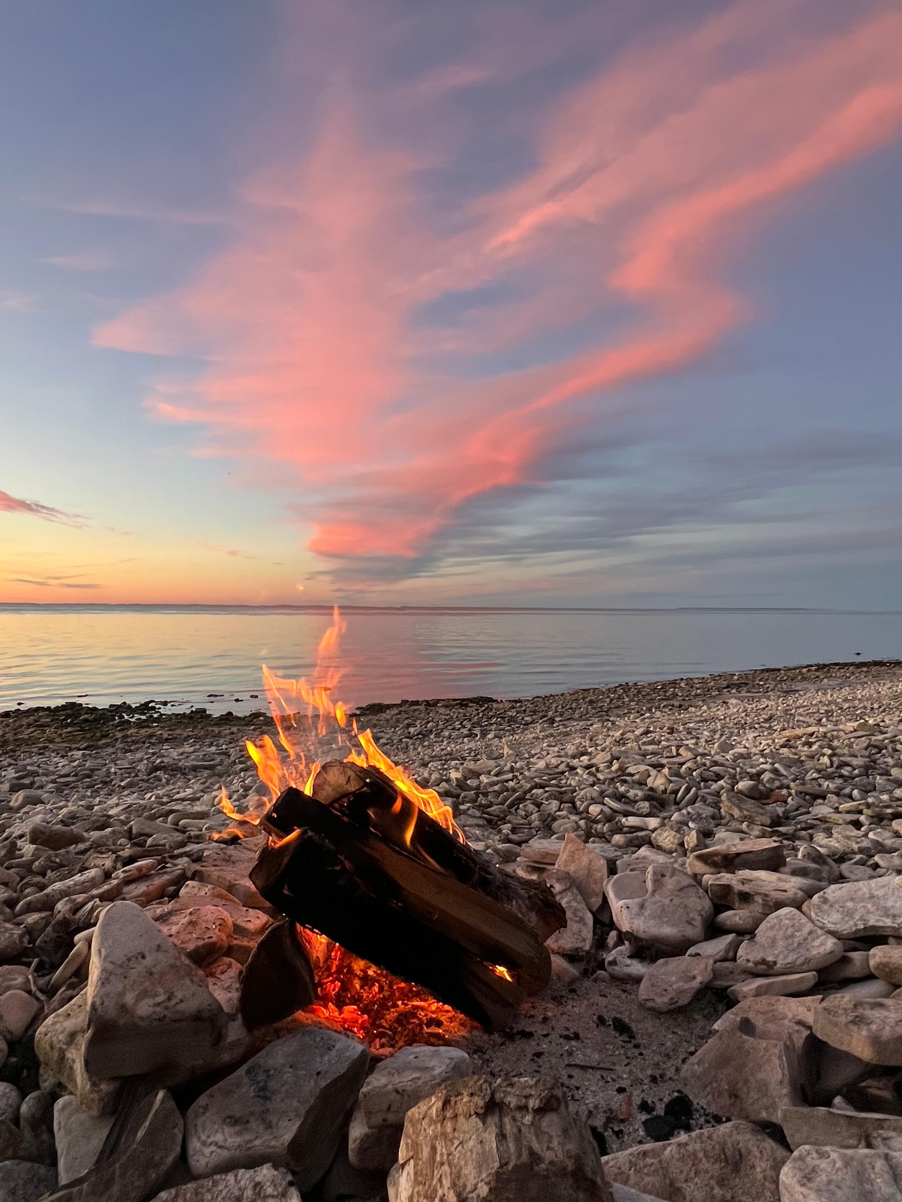 Campfire and sunset on beach in front of cottage 