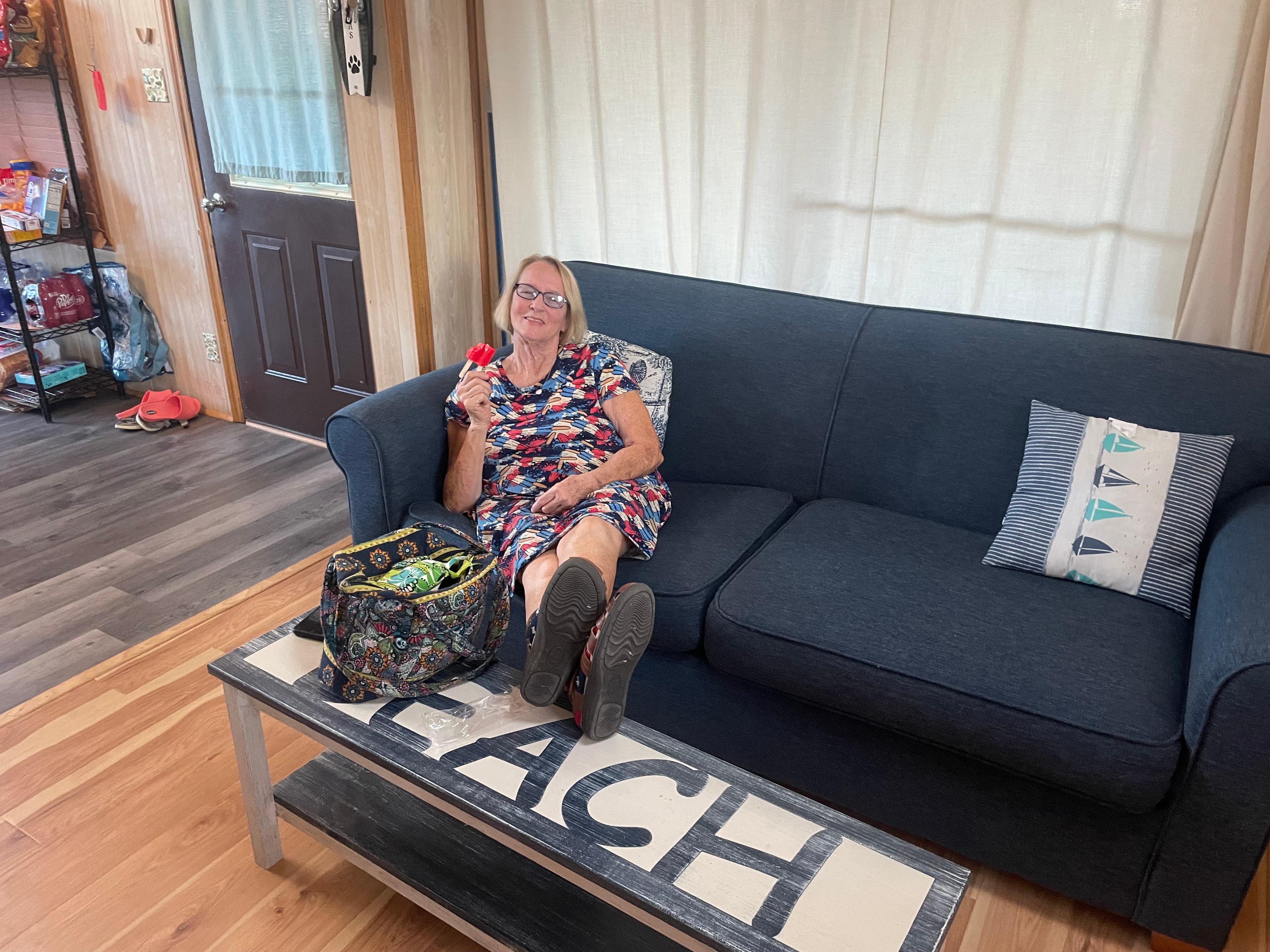 My mom relaxing in the living room watching her grandkids play the Pac-Man game. 