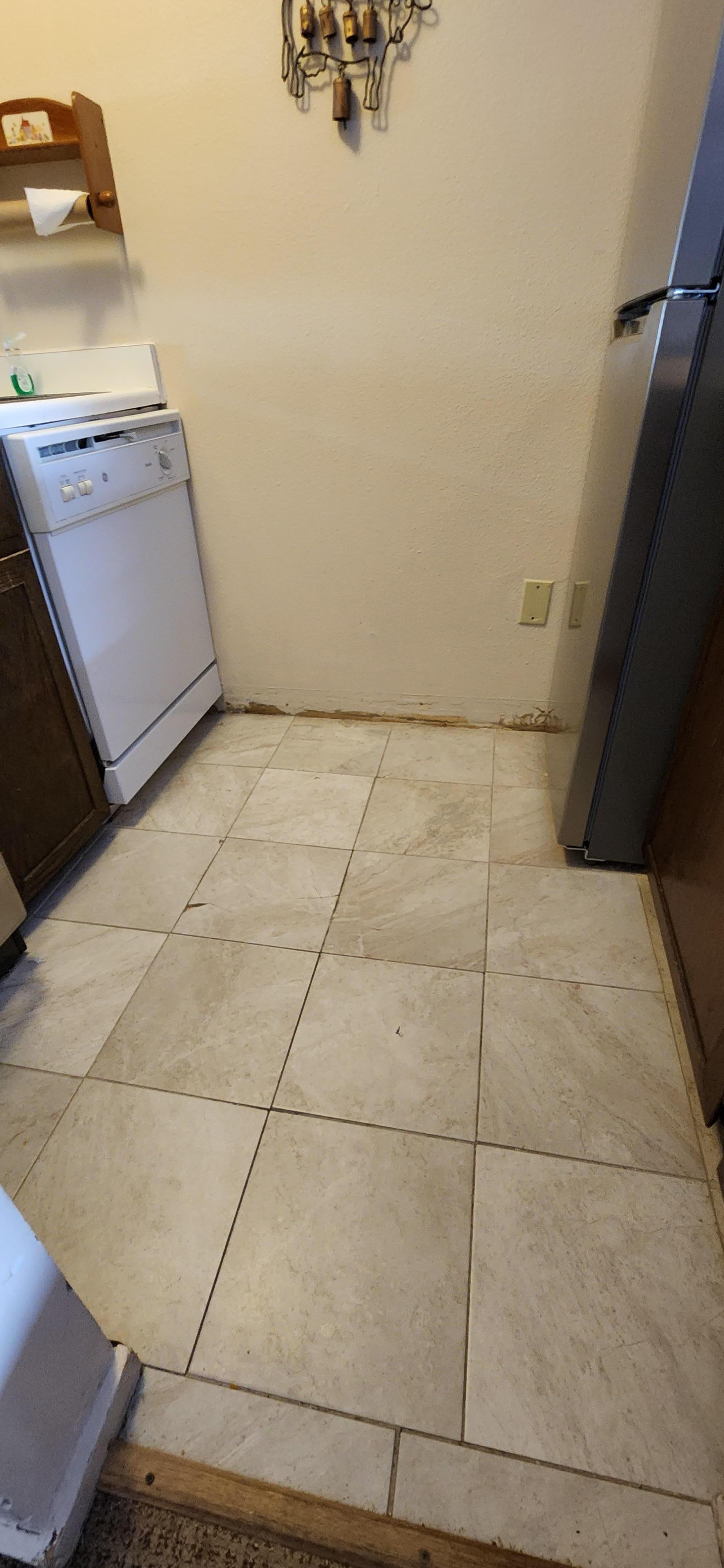 Missing baseboard and cracked tile.