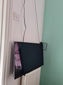 Wall mounted TV just resting on a radiator