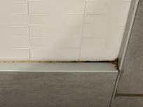 On baseboard in bathroom.