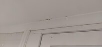 Moisissures sur le mur au dessus de la porte de la salle de bain.