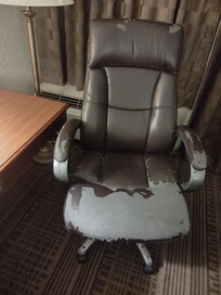 Desk chair in room. Comfy but trashy.