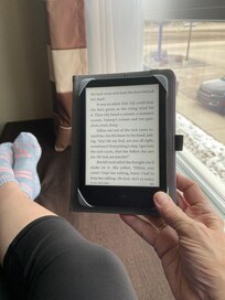 Sitting in the window seat reading.