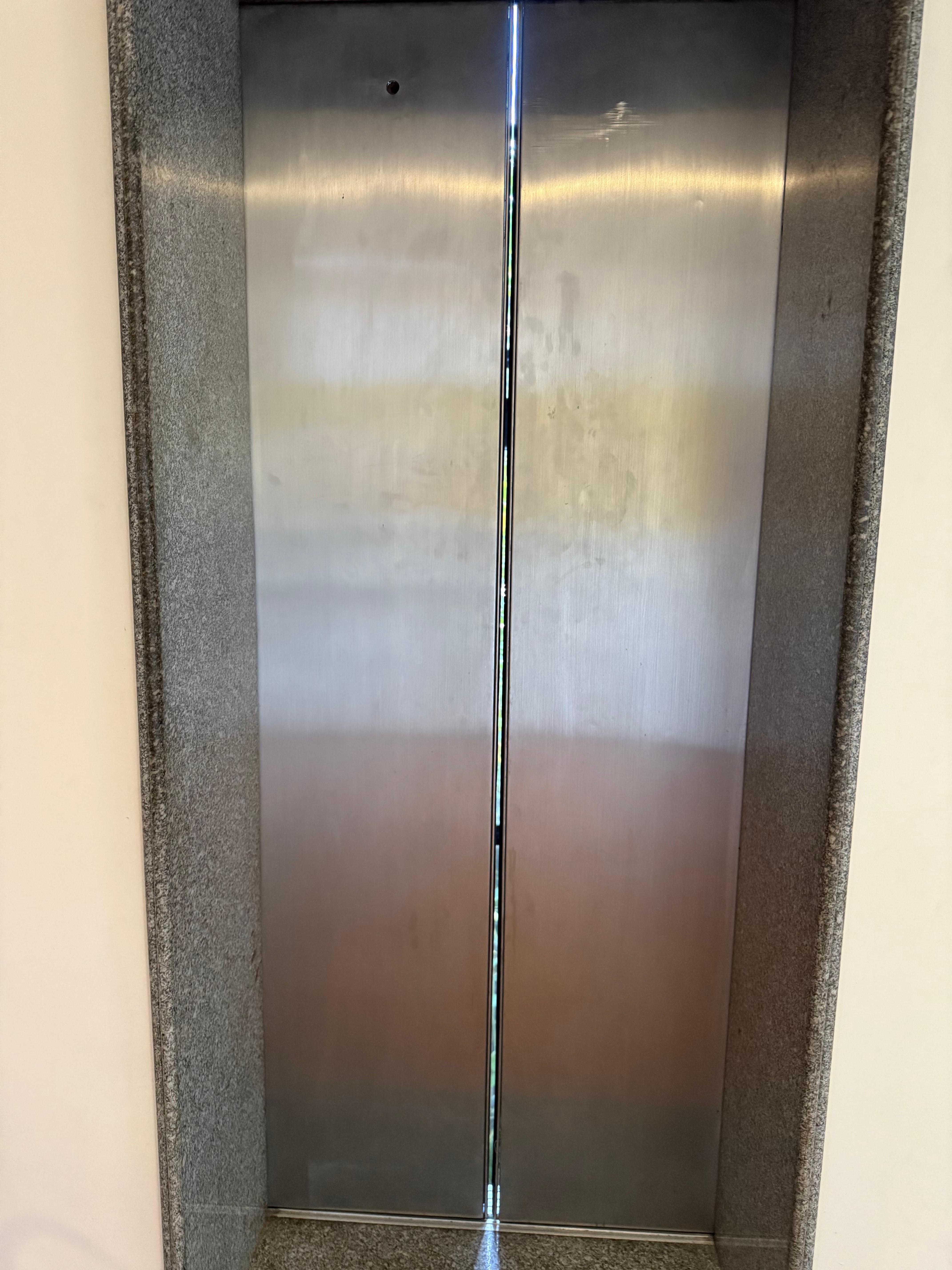 É possível ver que a porta do elevador não fecha por completo, mostrando que precisa de manutenção geral no hotel