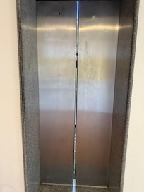 É possível ver que a porta do elevador não fecha por completo, mostrando que precisa de manutenção geral no hotel