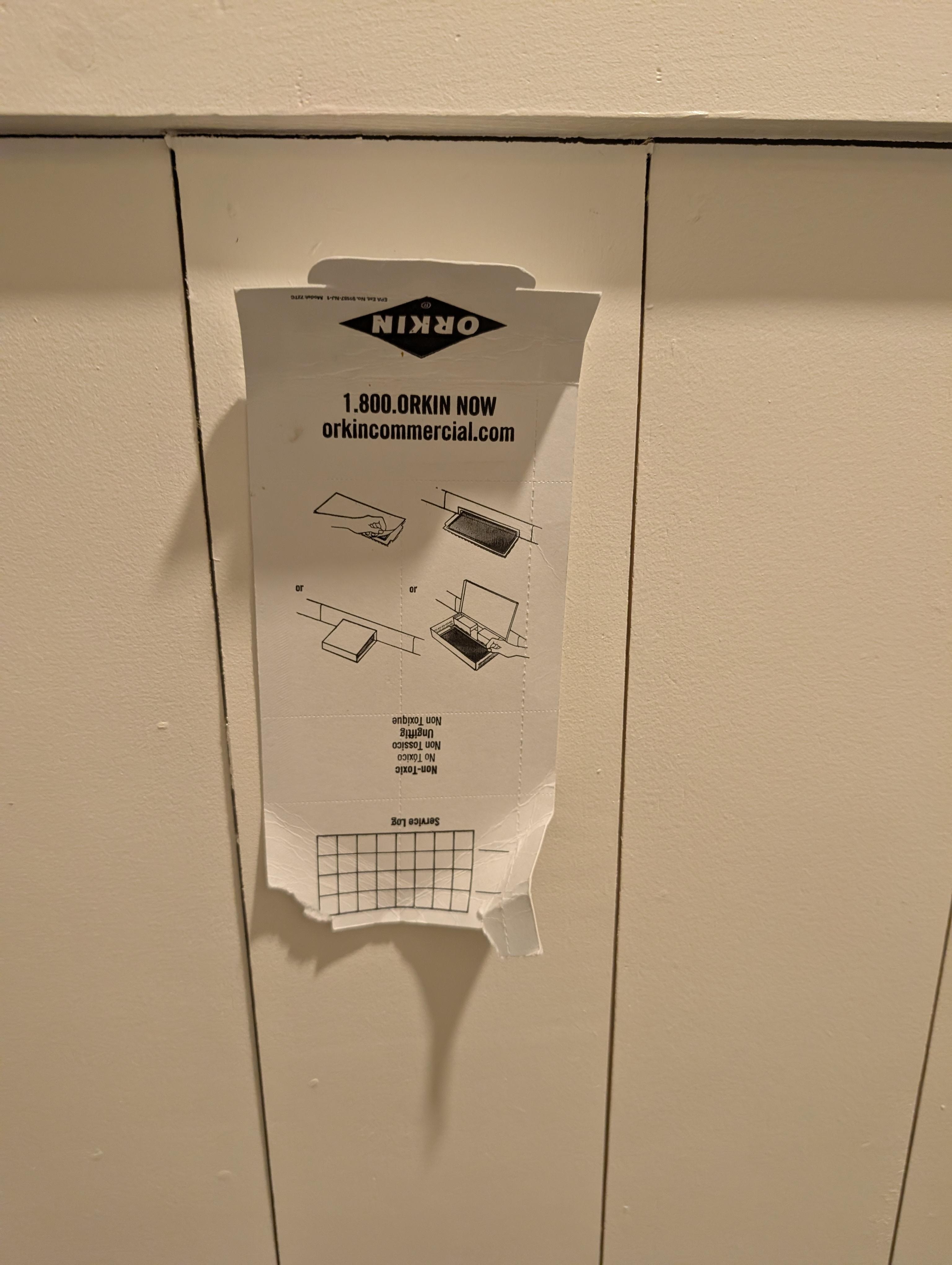 Orkin man instructions for a rodent trap tapped to the wall