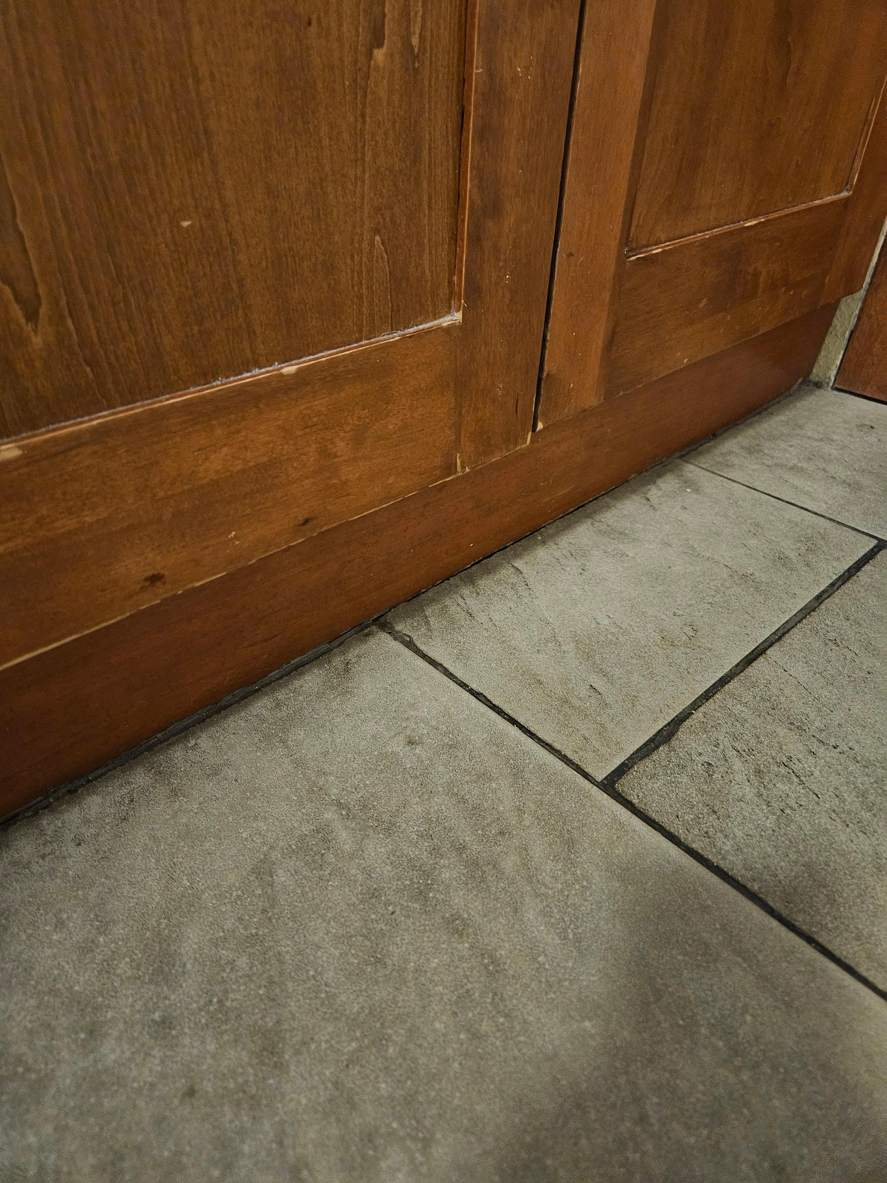 Dirt caked around the tile floor.