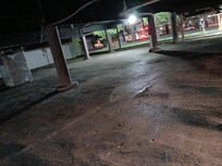 Under building fenced in with barbed wire. Broken bottles everywhere.