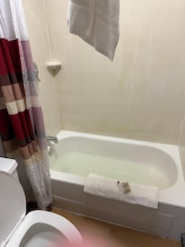 Tub full of water and bathroom not cleaned