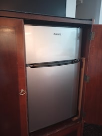 Hidden in the wardrobe cabinet are a nice fridge and freezer