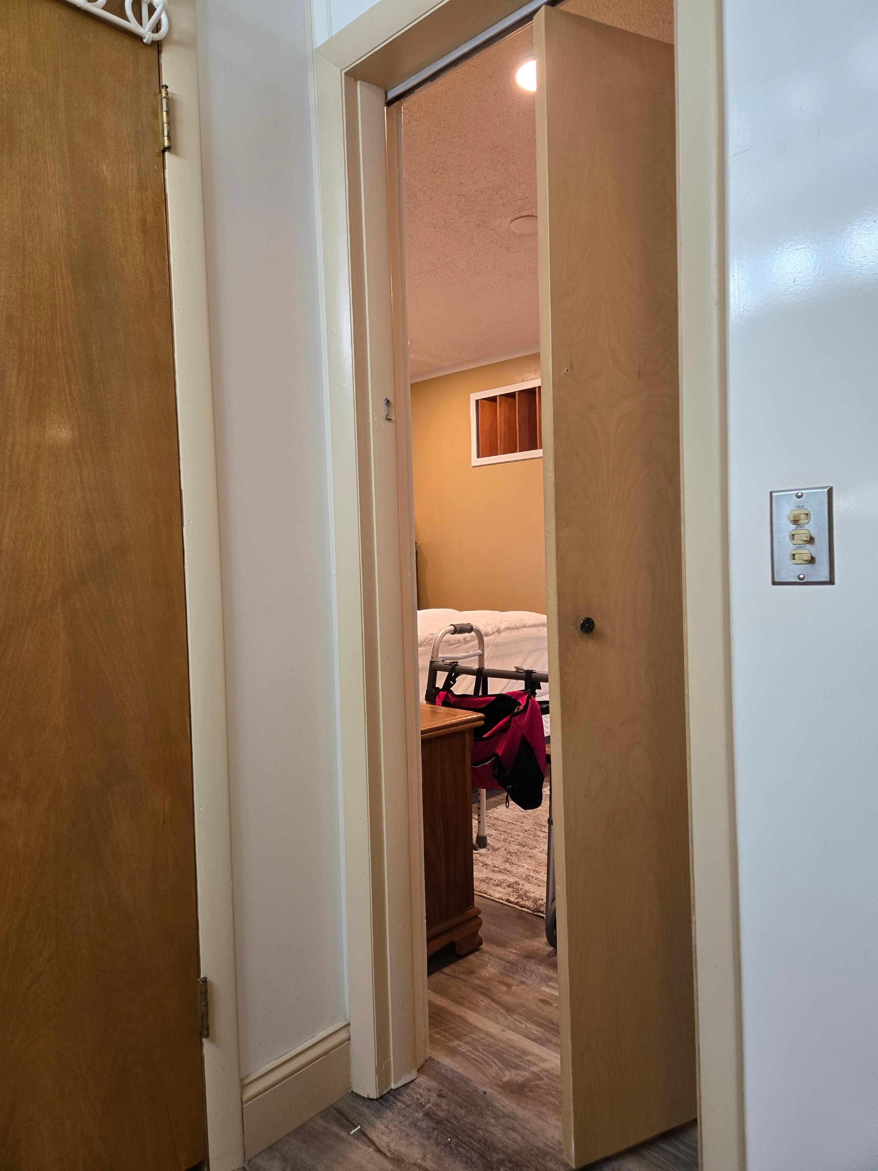 Bathroom entrance from main bedroom. Note walker next to bed and height of bed. Also door inaccessible for walker.  Significantly too narrow. I had to grab onto the the linen closet doorknob then the sink in order to access the bathroom. Dangerous!