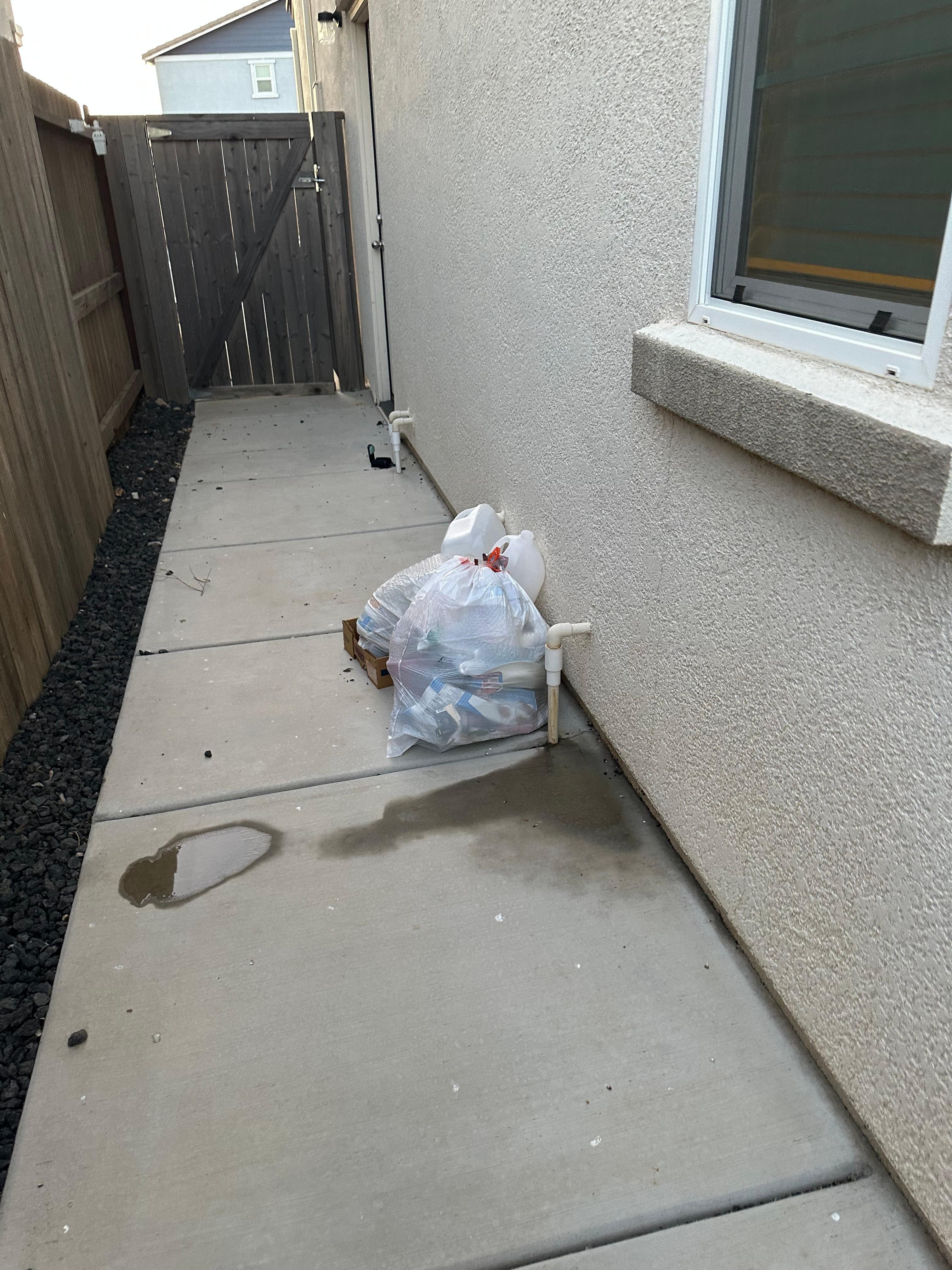 Trash along the side of the house 