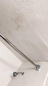 Above shower. And NO fan