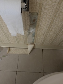 Wallpaper in bathroom torn and left